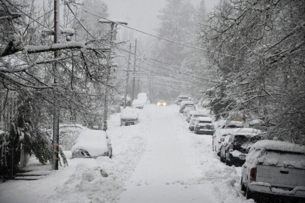A vehicle attempts to drive along a snow-covered street in downtown Grass Valley, Calif., during a snowstorm, on Feb. 28, 2023. (Elias Funez/The Union via AP)
