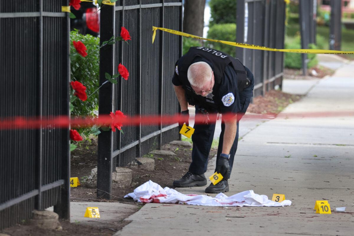 Police investigate a crime scene where three people were shot at the Wentworth Gardens housing complex in the Bridgeport neighborhood in Chicago, Ill., on June 23, 2021. (Scott Olson/Getty Images)