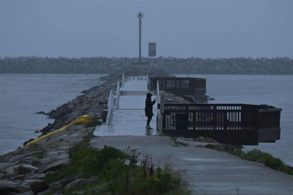 A person takes pictures along Ballona Creek as storm water runoff from a winter rain storm flows into the Pacific Ocean in Marina Del Rey community of unincorporated Los Angeles County, Calif., on March 14, 2023. (Patrick T. Fallon/AFP via Getty Images)