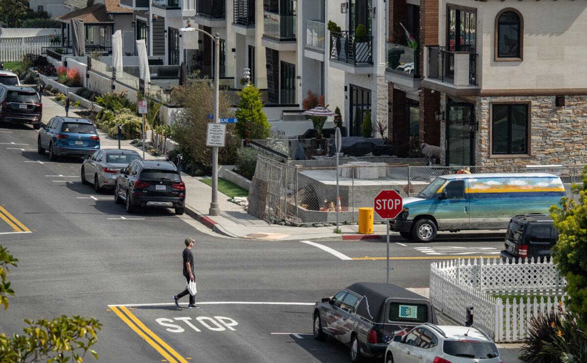 A man walks by housing units in Huntington Beach, Calif., on March 17, 2023. (John Fredricks/The Epoch Times)
