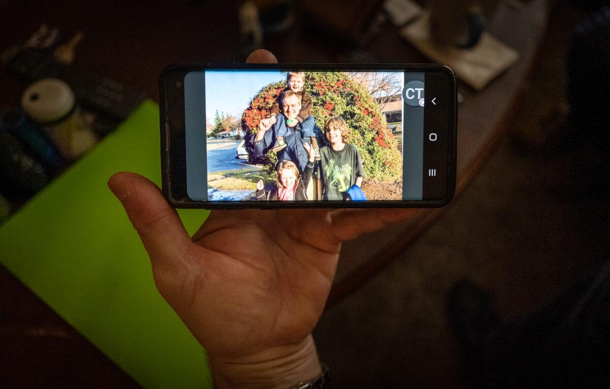 Brett Bowman looks at a photo of his children including his deceased son, Skyler, in Chico, Calif., on March 12, 2023. (John Fredricks/The Epoch Times)