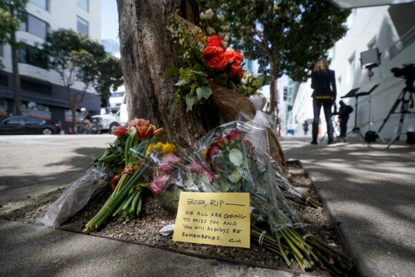 Flowers sit at a tree near where a technology executive was fatally stabbed in San Francisco on April 6, 2023. (Jeff Chiu/AP Photo)