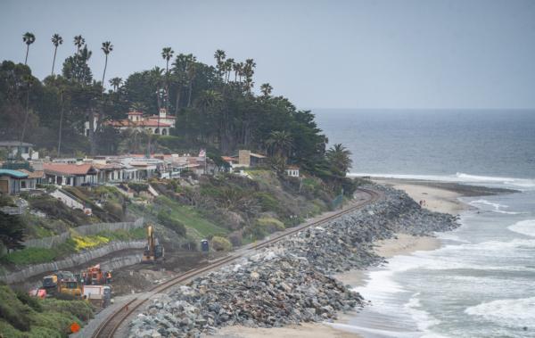 Workers fix track of the Amtrack coastal railway line in San Clemente, Calif. on April 13, 2023. (John Fredricks/The Epoch Times)