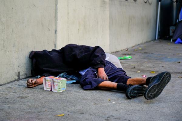 A homeless man sleeps on the streets of Los Angeles, California in December 2018. (John Fredricks/The Epoch Times)