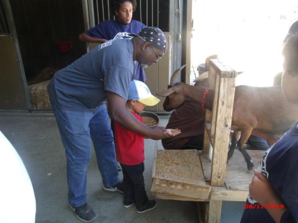 Chief Ministry Officer Derrick Burton (L), chief ministry officer of the Christian-based nonprofit Orange County Rescue Mission, assists a boy participating in the boys' camp at the Double R Ranch in San Diego County, Calif., on Aug. 17, 2019. (Courtesy of Orange County Rescue Mission)