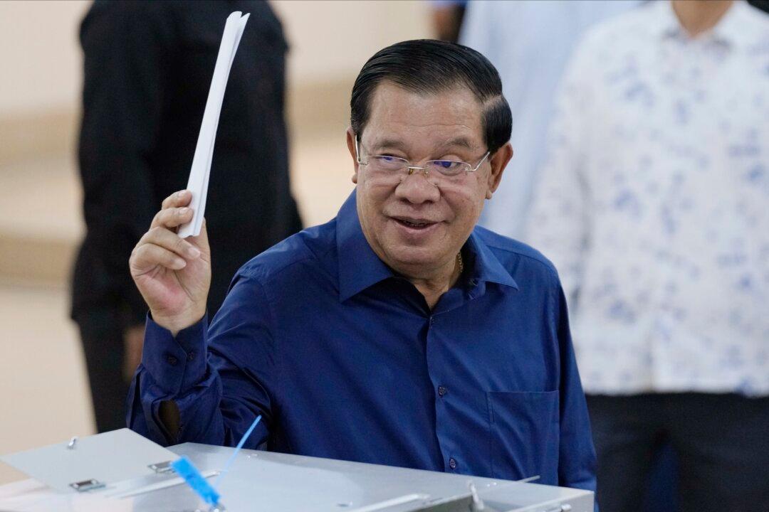 Cambodian Prime Minister Hun Sen raises a ballot before voting at a polling station in Ta Khmau, Cambodia, on July 23, 2023. Cambodia extradited Chen Zhi, chairman of the Prince Group, to China on Jan. 7, 2026. (Heng Sinith/AP Photo)