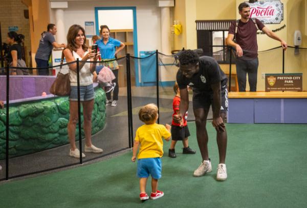 A player of the Orange County Soccer Club bumps fists with a boy at the Pretend City Children’s Museum in Irvine, Calif., on July 28, 2023. (John Fredricks/The Epoch Times)
