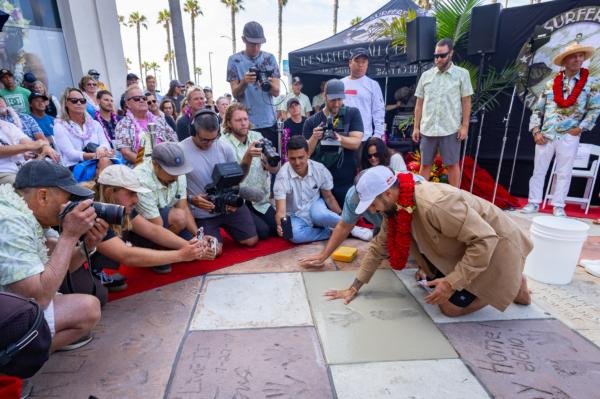 Surfer Italo Ferreira imprints his hands and feet at the Surfers Hall of Fame celebration in Huntington Beach, Calif., on Aug. 4, 2023. (John Fredricks/The Epoch Times)