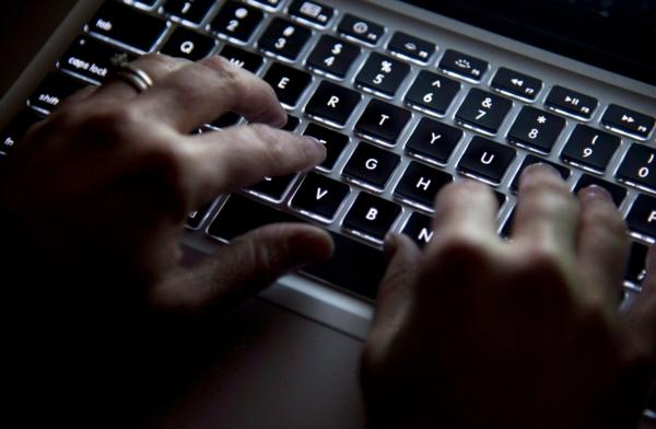 A woman uses her computer keyboard to type while surfing the internet in North Vancouver, B.C., on Dec., 19, 2012. (The Canadian Press/Jonathan Hayward)