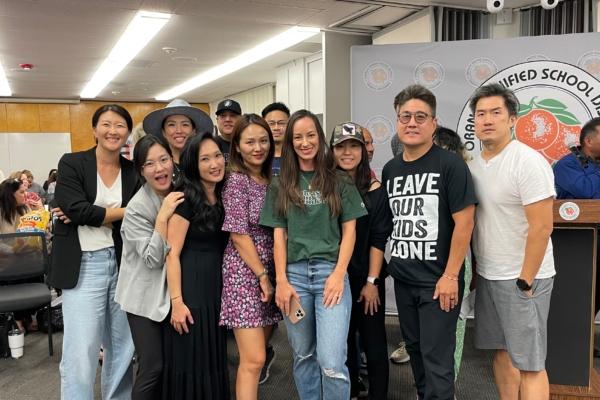 Supporters of a school district policy to notify parents when their child wishes to identify as transgender pose for a photo at an Orange Unified School Board meeting in Orange, Calif., on Sept. 7, 2023. (Mei Lee/The Epoch Times)