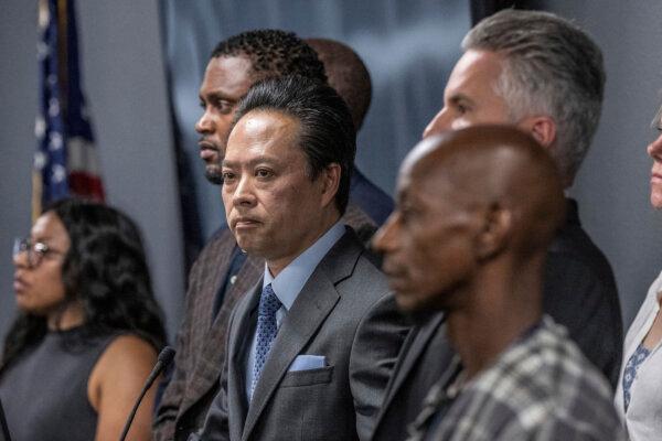 Sacramento County District Attorney Thien Ho (C) stands with supporters and victims of alleged crimes by homeless residents at a news conference announcing that his office is suing the city of Sacramento, on Sept. 19, 2023. (Hector Amezcua/The Sacramento Bee via AP)