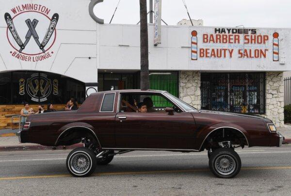 Families drive lowrider cars through the streets during the annual Labor Day parade and rally in Long Beach, Calif., on Sept. 3, 2018. (Mark Ralston/AFP via Getty Images)