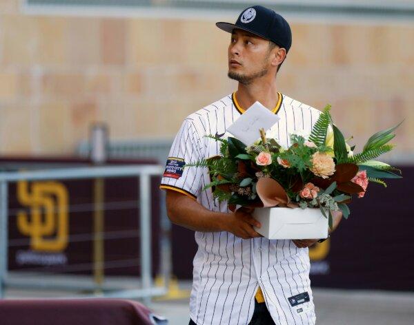 San Diego Padres pitcher Yu Darvish walks up to lay flowers at a public memorial on the steps of Petco Park in San Diego for Padres owner Peter Seidler on Nov. 14, 2023. (K.C. Alfred/The San Diego Union-Tribune via AP)