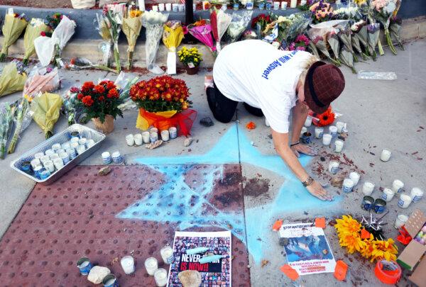 Elena Colombo creates a Star of David at a makeshift memorial at the site of an altercation between 69-year-old Paul Kessler, who was Jewish, and pro-Palestinian protestor, which resulted in Mr. Kessler's death, in Thousand Oaks, Calif., on Nov. 7, 2023. (Mario Tama/Getty Images)