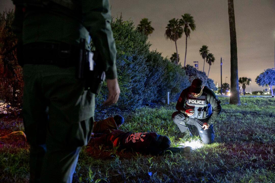 Border Patrol agents and Texas law enforcement officers detain illegal immigrants near the U.S.–Mexico border in McAllen, Texas, on Dec. 1, 2022. (John Moore/Getty Images)