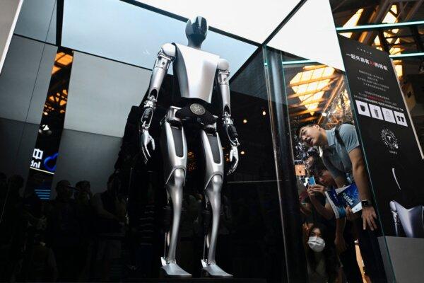 Visitors watch a Tesla robot displayed at the World Artificial Intelligence Conference (WAIC) in Shanghai on July 6, 2023. (Wang Zhao/AFP via Getty Images)