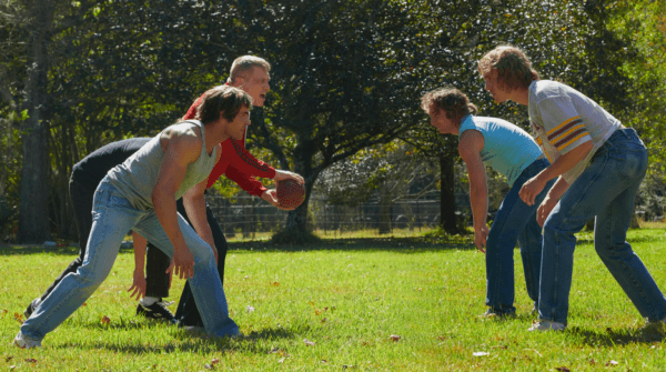(L–R) Kevin (Zac Efron), Fritz (Holt McCallany), Kerry (Jeremy Allen White), and David (Harris Dickinson) play football in "The Iron Claw." (A24/Lionsgate)