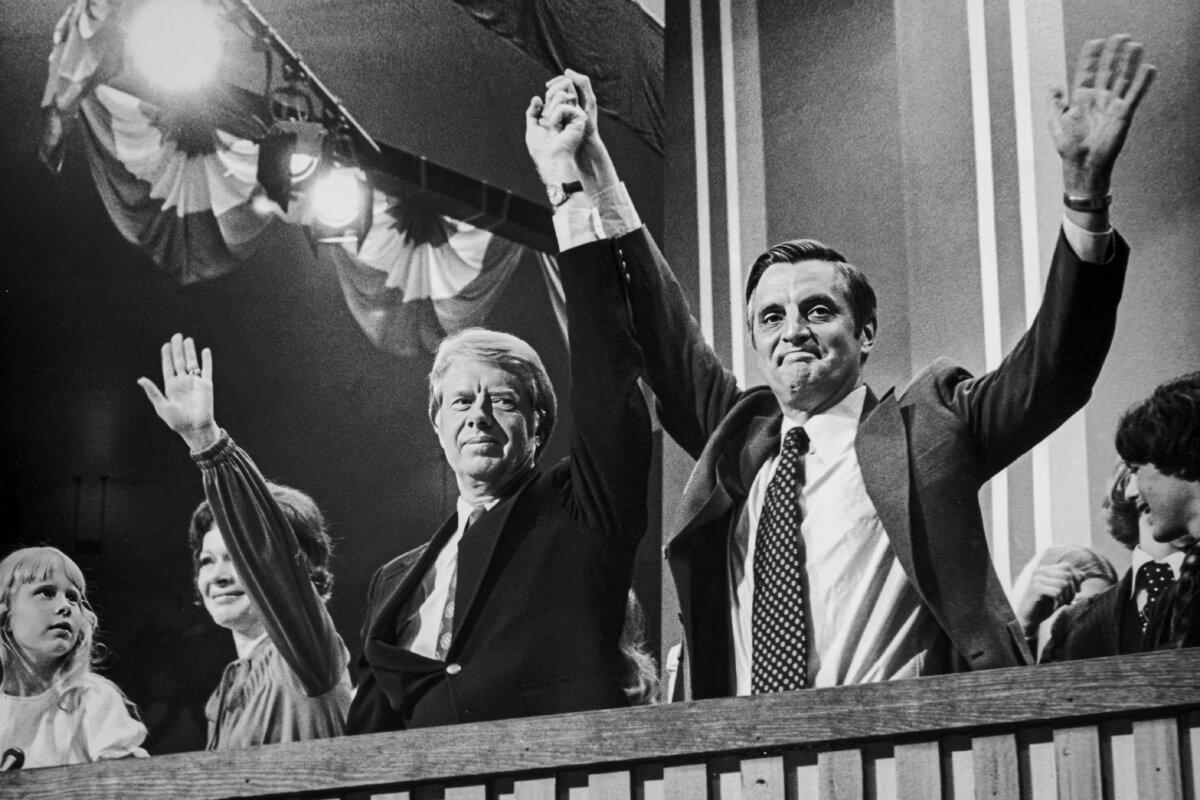 Democrat presidential nominee Jimmy Carter raises hands with vice presidential nominee Walter Mondale (R) at the Democratic National Convention in New York City on July 15, 1976. Carter's wife, Rosalynn, and their daughter Amy, wave beside them. (Hulton Archive/Getty Images)