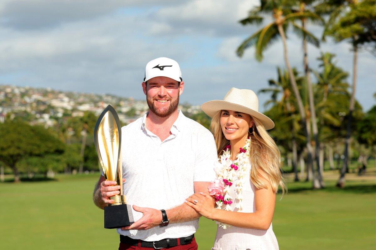 Grayson Murray of the United States and his fiancee Christiana pose with the championship trophy after a victory on the first play-off hole during the final round of the Sony Open in Hawaii at Waialae Country Club in Honolulu on Jan. 14, 2024. (Kevin C. Cox/Getty Images)