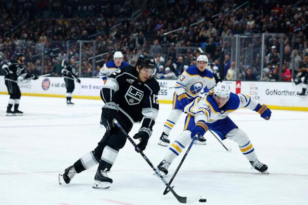 Trevor Moore (12) of the Los Angeles Kings skates the puck against Rasmus Dahlin (26) of the Buffalo Sabres in the second period in Los Angeles on Jan. 24, 2024. (Ronald Martinez/Getty Images)