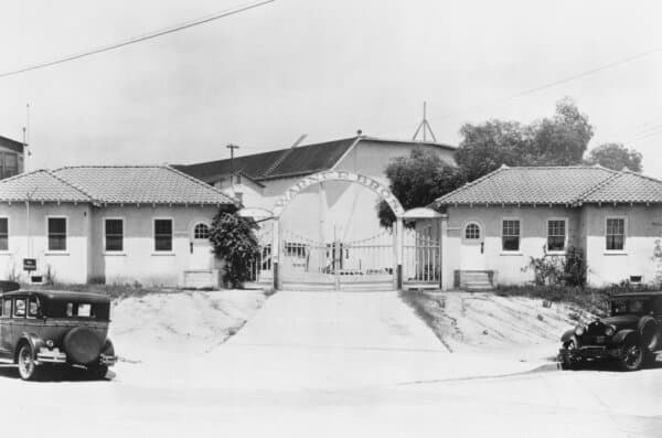 The gates, beneath an arched 'Warner Bros' sign, at the entrance to Warner Brothers Studios in Los Angeles, California, circa 1925. The studios were founded by Canadian-born brothers Jack Warner, Sam Warner, and Albert Warner in 1923. (Archive Photos/Getty Images)