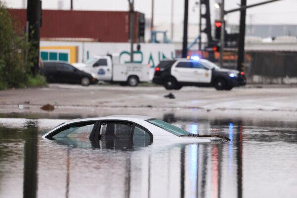 A car sits partially submerged on a flooded road during a storm in Long Beach, Calif., on Feb. 1, 2024. (David Swanson/AFP via Getty Images)