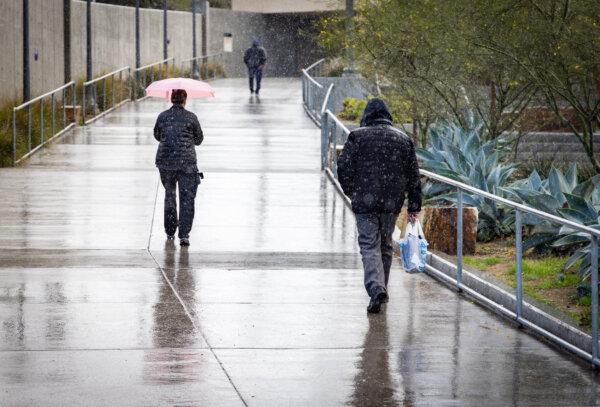 Rain falls as people walk in San Diego, Calif. on Feb. 2, 2024. (John Fredricks/The Epoch Times)