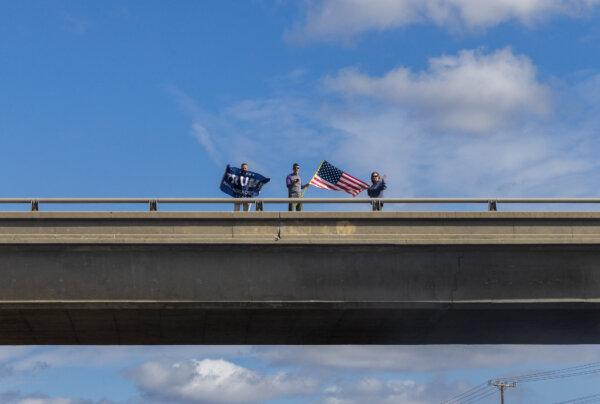 Supporters of a convoy protesting the status of open U.S. borders cheer on participants from freeway overpasses outside of Alpine, Calif., on Feb. 3, 2024. (John Fredricks/The Epoch Times)