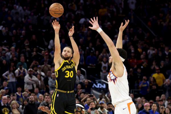 Golden State Warriors guard Stephen Curry (30) shoots against Phoenix Suns guard Devin Booker  during a game in San Francisco on Feb. 10, 2024. (Jed Jacobsohn/AP Photo)