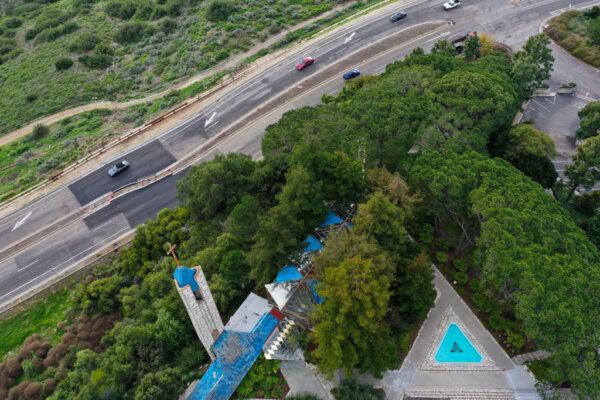 An aerial image shows vehicles driving on a damaged section of road past the Wayfarers Chapel in a landslide prone area following its closure due to land movement after heavy rains in Rancho Palos Verdes, Calif., on Feb. 16, 2024. (Patrick T. Fallon/AFP via Getty Images)