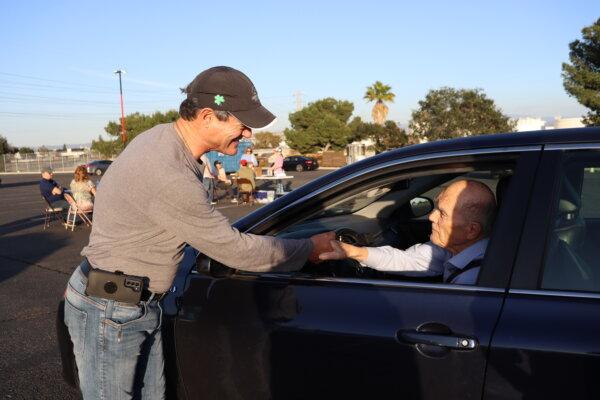 Orange County District Attorney Todd Spitzer shakes the hand of a participant for a Prop. 47 reform signature collection drive-thru event hosted by KFI radio at the Honda Center in Anaheim, Calif., on Feb. 22, 2024. (Mei He/The Epoch Times)