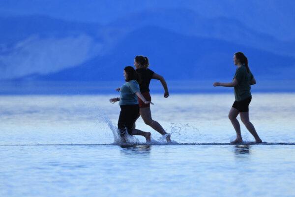 Tourists enjoy the rare opportunity to walk in water as they visit Badwater Basin, the normally driest place in the US, in Death Valley National Park, Inyo County, Calif., on Feb. 18, 2024. (David Swanson/AFP via Getty Images)