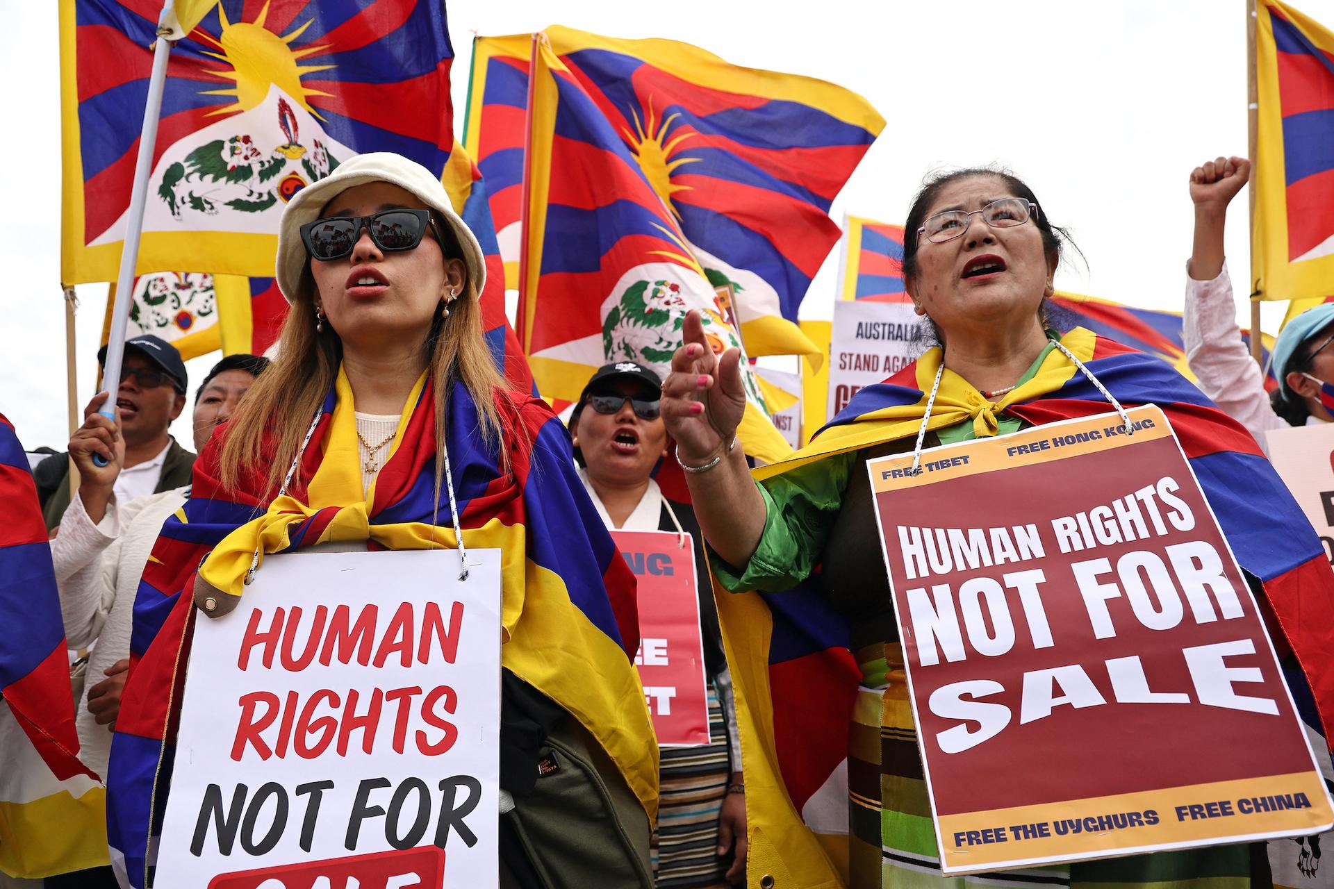 Members of the Australian Tibetan community hold flags and placards as they protest at a rally organized by the Alliance for Victims of the Chinese Communist Regime outside Parliament House in Canberra, Australia, on March 20, 2024. (David Gray/AFP via Getty Images)