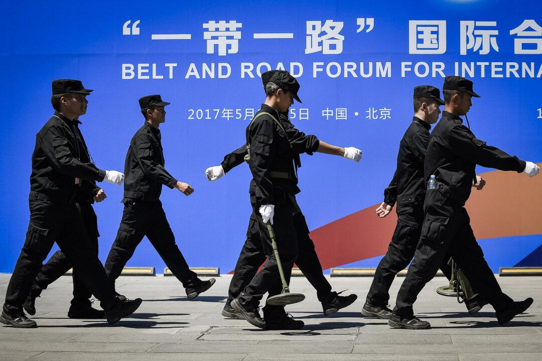 Security guards walk past a billboard for the Belt and Road Forum for International Cooperation at the forum venue in Beijing on May 13, 2017. (Wang Zhao/AFP via Getty Images)