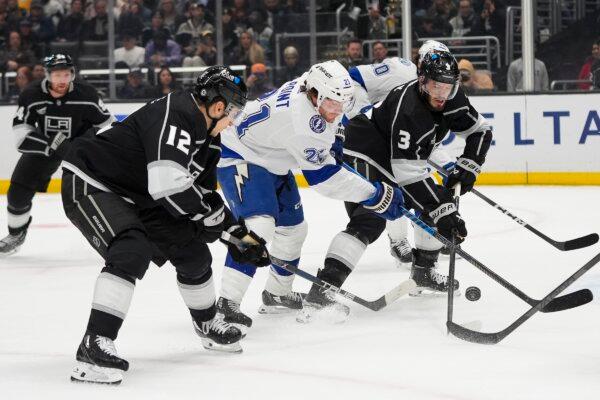 Los Angeles Kings' Trevor Moore (12) and Matt Roy (3) defend against Tampa Bay Lightning's Brayden Point (21) during the first period of an NHL hockey game in Los Angeles on March 23, 2024. (Jae C. Hong/AP Photo)