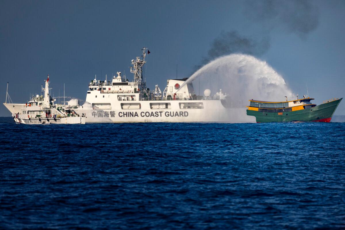 A Chinese Coast Guard ship fires a water cannon at Unaizah on May 4, a Philippine Navy chartered vessel, conducting a routine resupply mission to troops stationed at Second Thomas Shoal, in the South China Sea, on March 5, 2024. (Ezra Acayan/Getty Images)