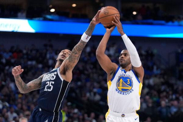 Chris Paul of the Warriors attempts to shoot against the Dallas Mavericks' P.J. Washington in Dallas on April 5, 2024. (LM Otero/AP Photo)