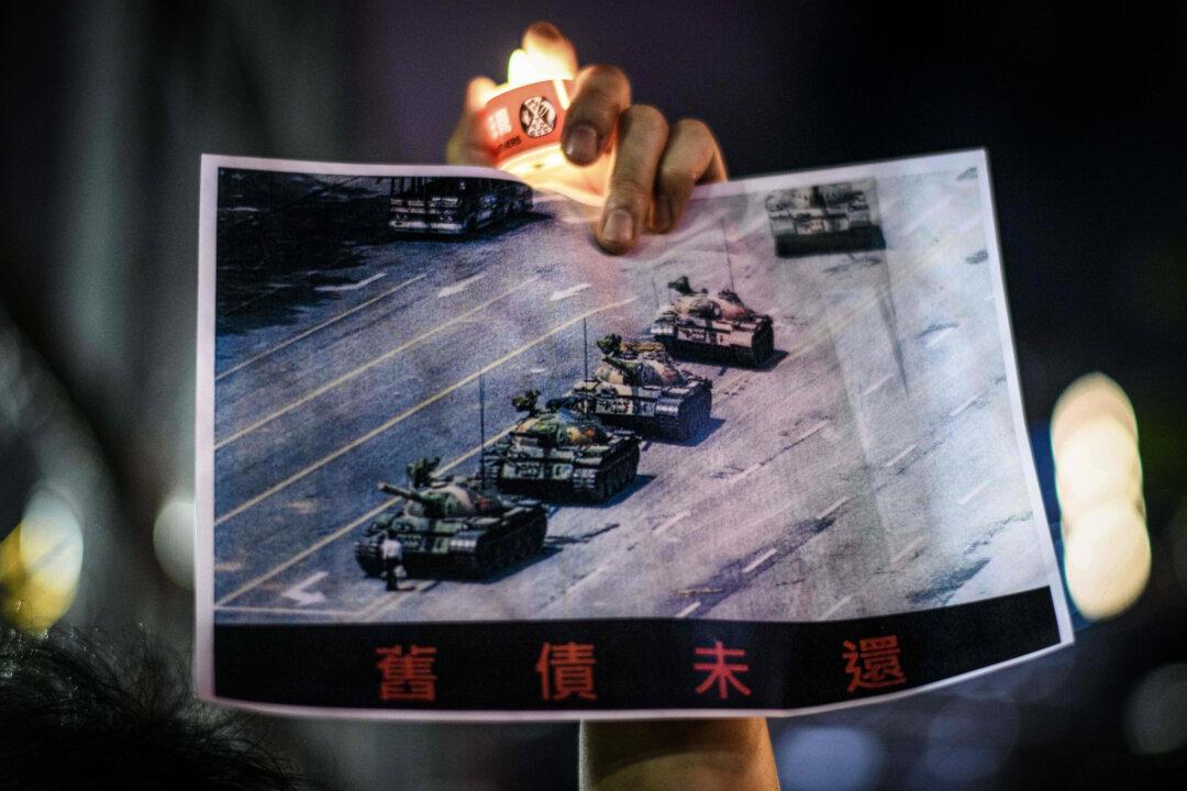 A man holds a poster of the famous “Tank Man” standing in front of Chinese military tanks at Tiananmen Square in Beijing on June 5, 1989, during a commemoration of the 1989 Tiananmen Square event, in Victoria Park in Hong Kong on June 4, 2020. (Anthony Wallace/AFP via Getty Images)
