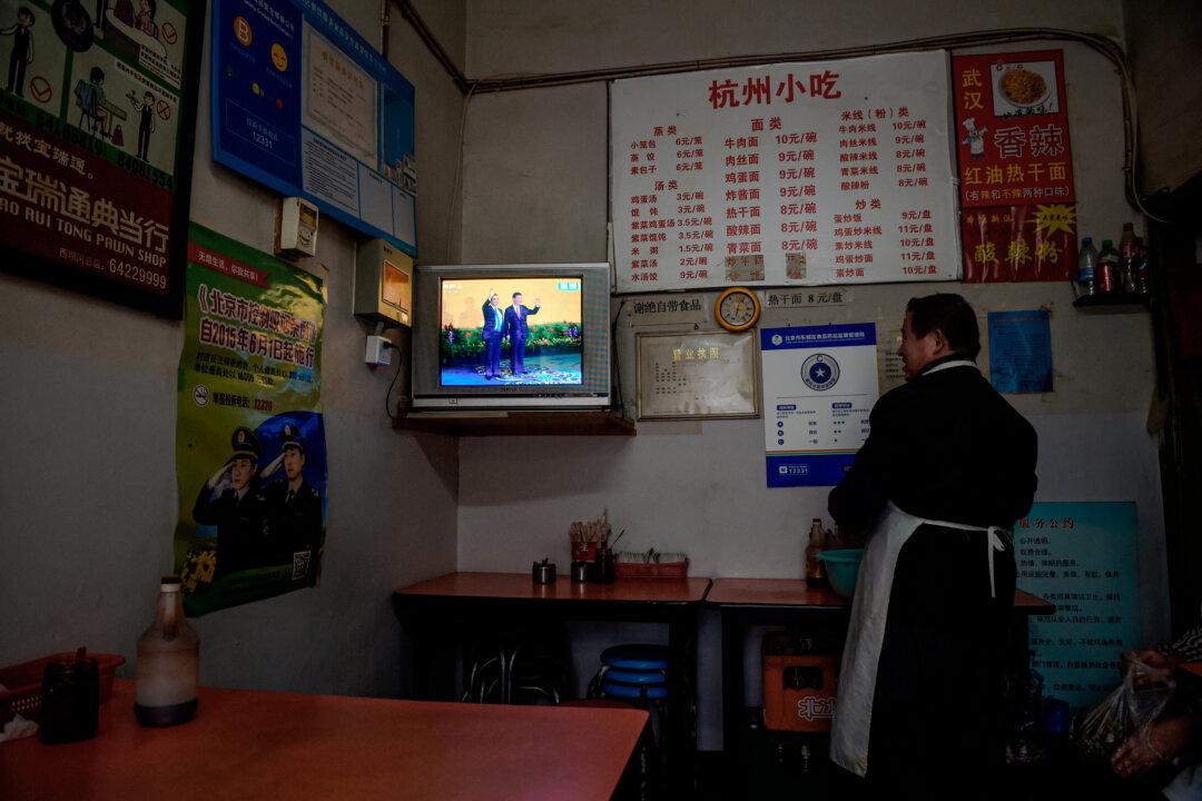 A restaurant owner watches live television coverage of a meeting in Beijing between Chinese leader Xi Jinping and Taiwanese President Ma Ying-jeou, in Singapore on Nov. 7, 2015. (Greg Baker/AFP via Getty Images)
