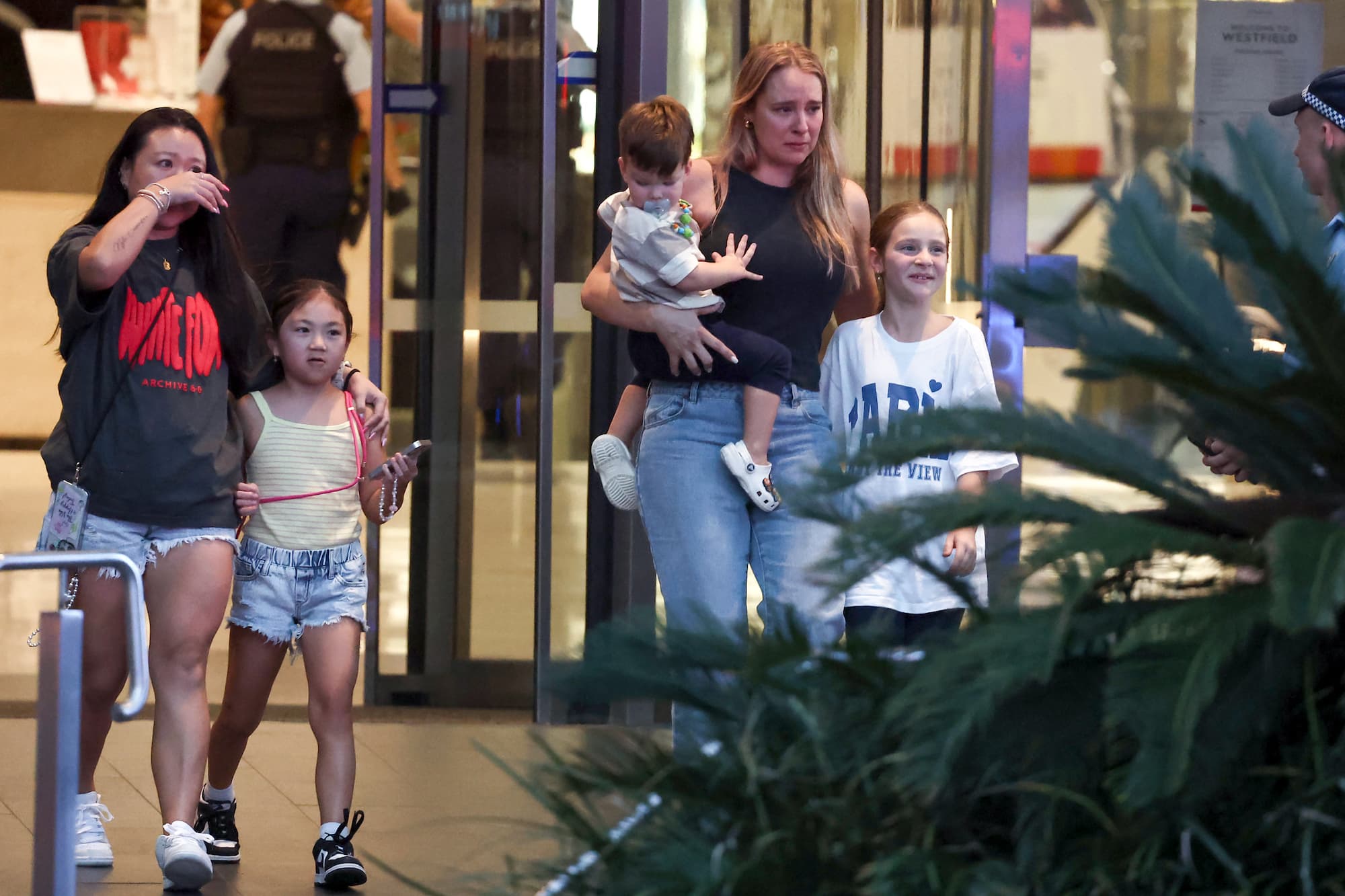 Families walk out of the Westfield Bondi Junction shopping mall after a stabbing incident in Sydney on April 13, 2024. (David Gray/ AFP via Getty Images)