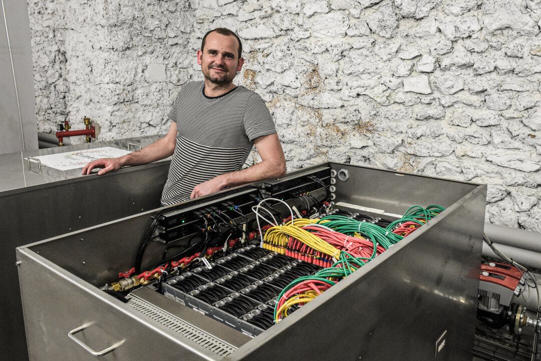 Founder and CEO of Stimergy, Christophe Perron, poses in front of his company's digital boiler installed at a municipal swimming pool, which uses it's heat, in Paris on April 18, 2018. (Eric Piermont/AFP via Getty Images)