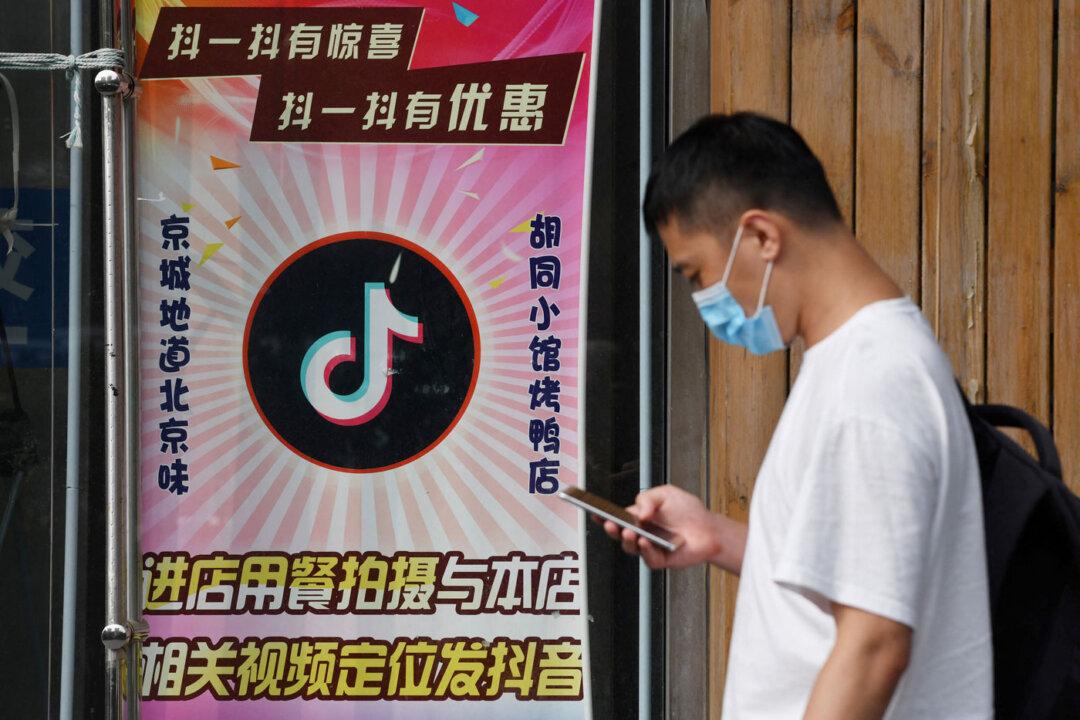 A man walks past a restaurant with a TikTok logo displayed in the window in Beijing on Sept. 14, 2020. (Greg Baker/AFP via Getty Images)