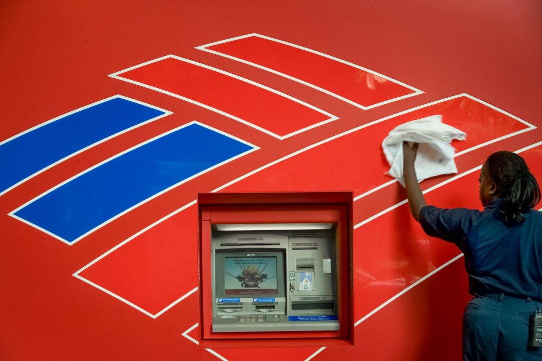 A staff member cleans an ATM machine across the street from Bank of America's headquarters in Charlotte, N.C., on Sept. 15, 2008. Mr. Eastman has been allegedly de-banked by Bank of America. (Davis Turner/Getty Images)