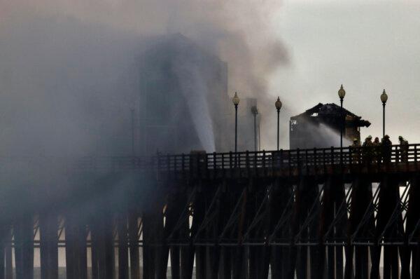 Firefighters try to extinguish a fire burning on the West end of the Oceanside Pier, in Oceanside, Calif., on April 25, 2024. (Sandy Huuffaker/AFP via Getty Images)