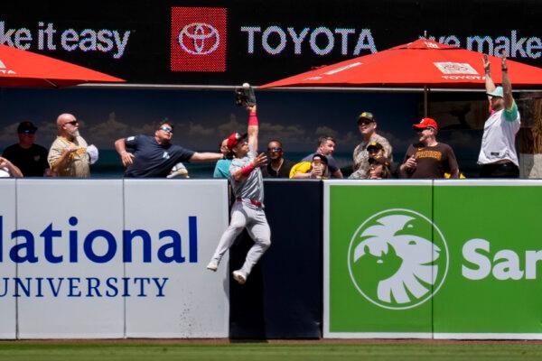 Reds center fielder Stuart Fairchild makes a leaping catch over the wall to take away a home run from the Padres' Manny Machado in San Diego on May 1, 2024. (Gregory Bull/AP Photo)