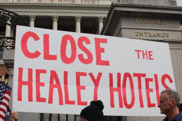 A giant sign protesting Massachusetts Gov. Maura Healey's support for unvetted immigrants over veterans was one of many on display in Boston on May 4, 2024. (Alice Giordano/The Epoch Times)