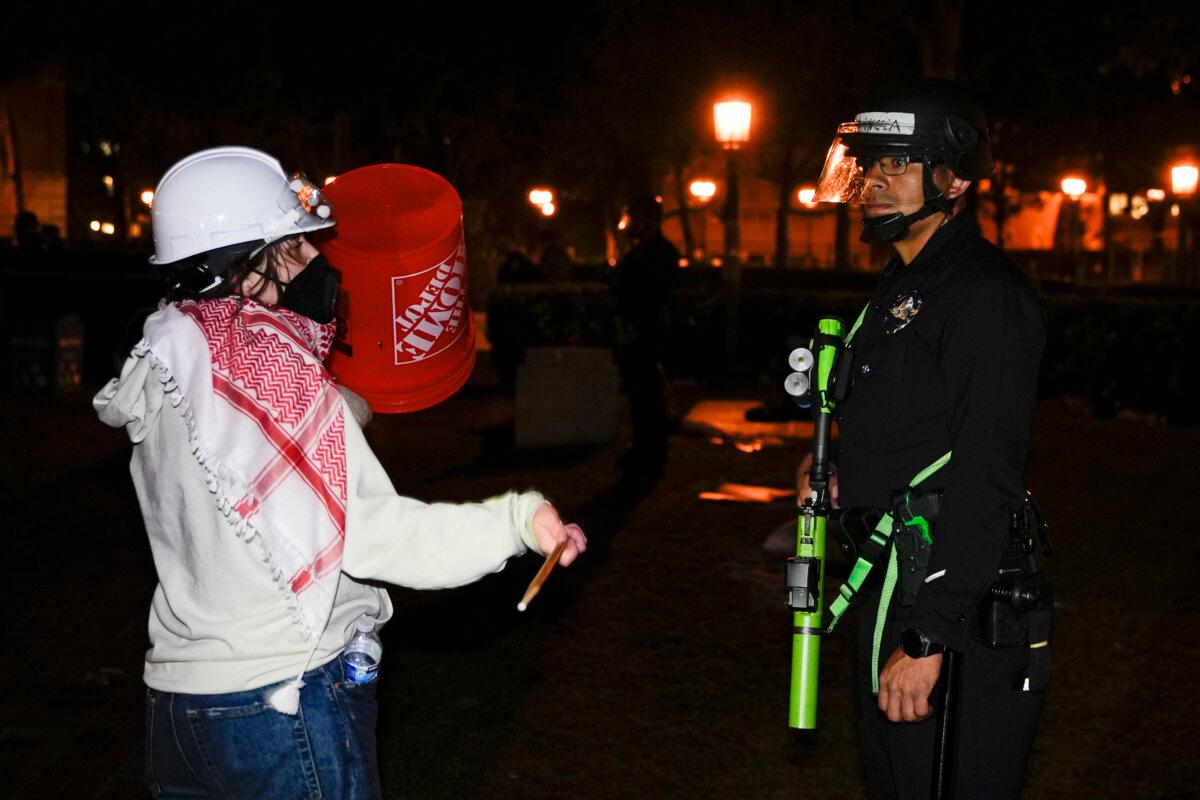 A person protests in front of a police officer after police arrived on the campus at the University of Southern California to clear an encampment set up by pro-Palestinian demonstrators in Los Angeles on May 5, 2024. (Ryan Sun/AP Photo)