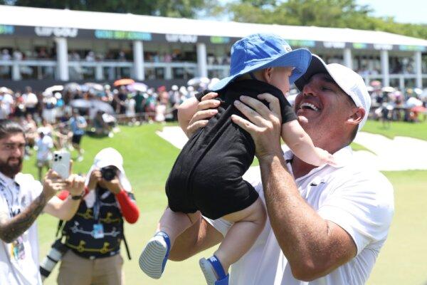 Brooks Koepka of Smash GC celebrates his victory with his son on the eighteenth green during day three of the LIV Golf Invitational– Singapore in Singapore on May 5, 2024. (Lionel Ng/Getty Images)
