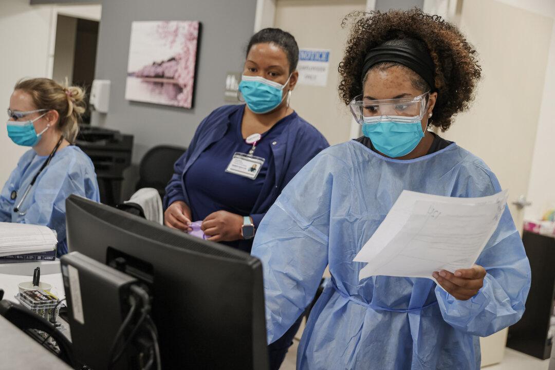 Health care workers fill out patient records in Woodbridge, Va., on April 15, 2020. (Chip Somodevilla/Getty Images)