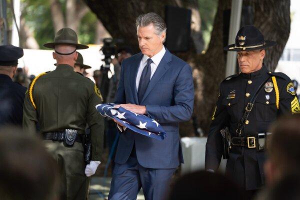 Gov. Gavin Newsom holds a U.S. flag at the 46th annual California Peace Officers' Memorial Ceremony in Sacramento on May 6, 2024. (Gov. Gavin Newsom's Office)